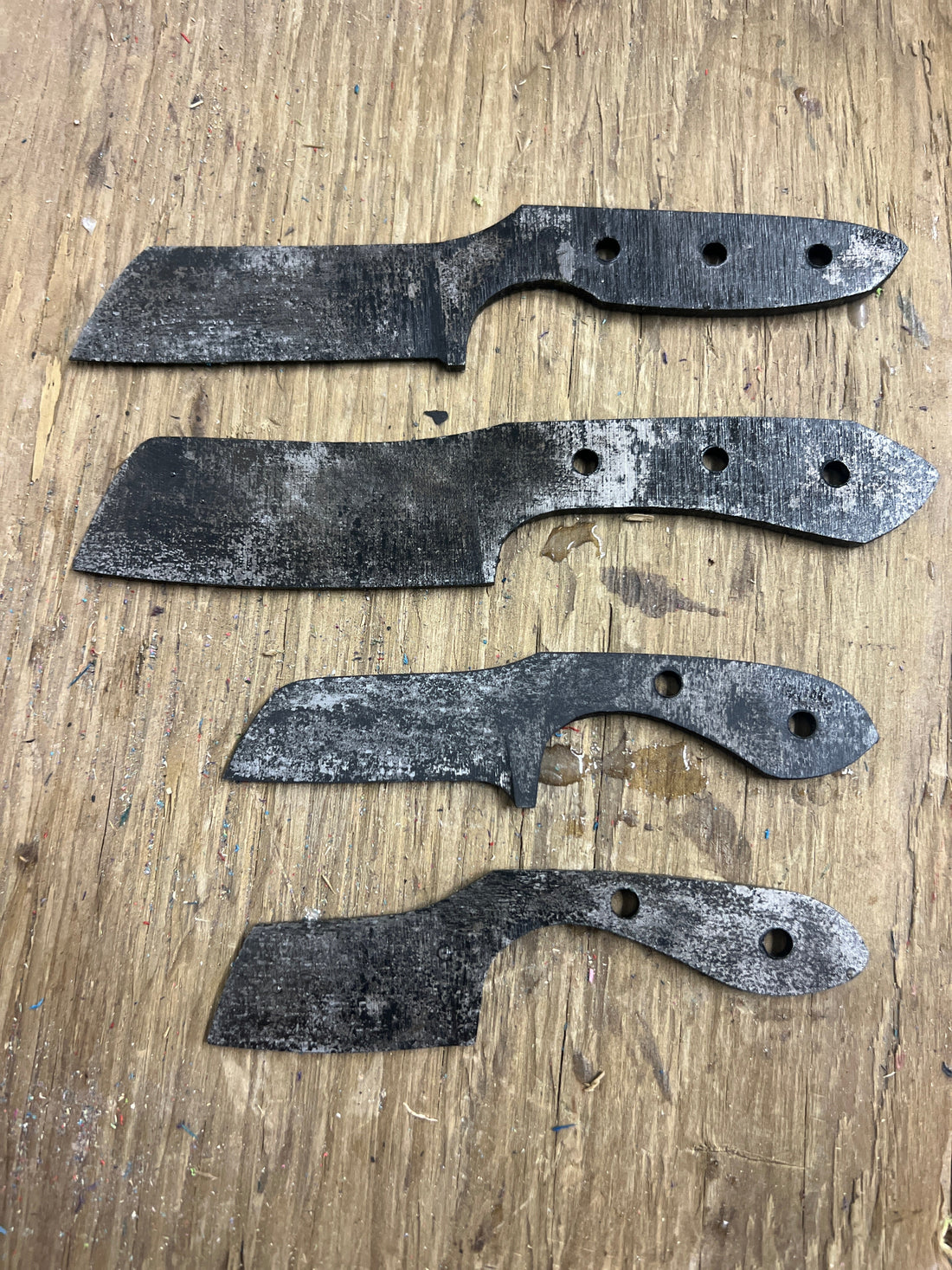 Set of custom blacksmith-forged knives after ferric chloride acid wash and stone tumbling, made during knife workshop at Oldboy Metal Co. in Toronto.