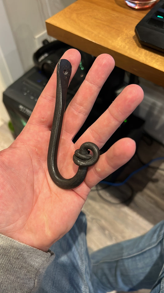 Hand-forged wall hook with decorative scroll, made during beginner blacksmithing workshop at Oldboy Metal Co. in Toronto.